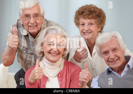 Vier Senioren mit Daumen hoch, Porträt Stockfoto