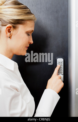 Frau Tür Tastatur drücken Stockfoto