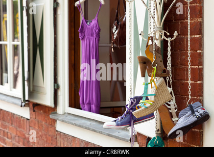 Sommerschuhe, die an eine Garderobe vor einem Fenster hängen Stockfoto