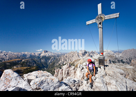 Wanderer auf dem Gipfelkreuz des Mt Paternkofel oder Paterno, Mt Schwalbenkofel und Mt Hohe Gaisl Croda Rossa in den Rücken Stockfoto