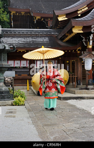 Miko, eine Schamanin trägt einen Öl-Papier-Regenschirm im Rahmen einer Feierstunde Imamiya Schrein, Herbstfest des Jidai-Matsuri, Kyoto Stockfoto