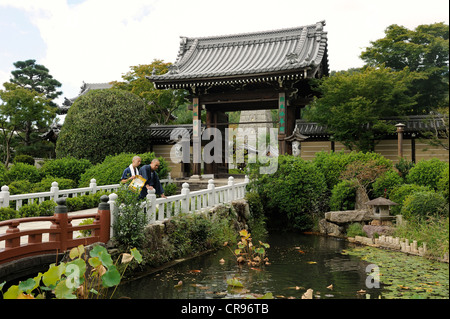 Buddhistische Mönche Fütterung Kois vor dem Tor des Entsuji Tempels, Iwakura in der Nähe von Kyoto, Japan, Asien Stockfoto