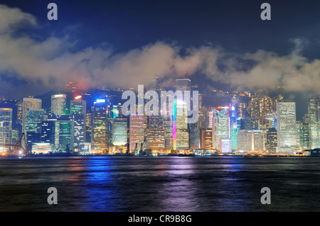 Hong Kong Skyline bei Nacht mit Wolken über den Victoria Harbour. Stockfoto