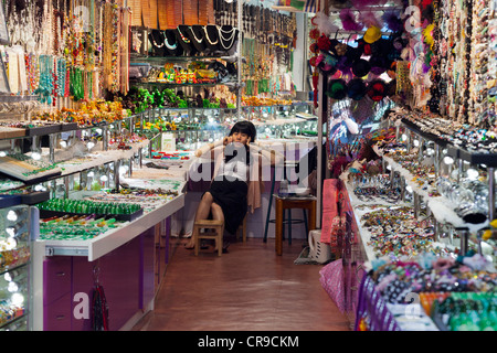 Stall - Keeper im Chat auf Handy in Stanley Market, Hong Kong Stockfoto