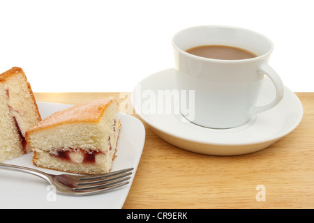 Nahaufnahme von einem Stück Himbeer Biskuit und eine Tasse Kaffee auf einer Holzfläche Stockfoto