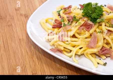 Käse-Spätzle mit Petersilie auf hölzernen Hintergrund Stockfoto