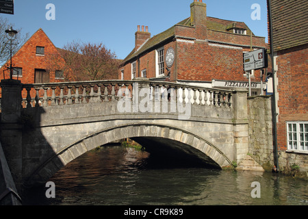 Winchester, Hampshire, England. Brücke über den Fluss Itchen mit der Stadt Mühle im Hintergrund. Stockfoto