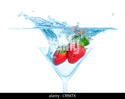 Frische Erdbeeren fiel in Glas mit Splash auf weißem Hintergrund Stockfoto