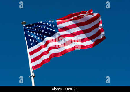 Die amerikanische Flagge auf einem Fahnenmast flattern Stockfoto