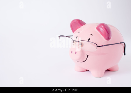 Rosa Sparschwein Lesebrille tragen. Studio mit einem einfarbigen Hintergrund aufgenommen. Stockfoto