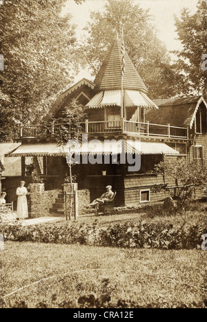 Älteres Ehepaar vor skurrilen viktorianische Cottage Stockfoto