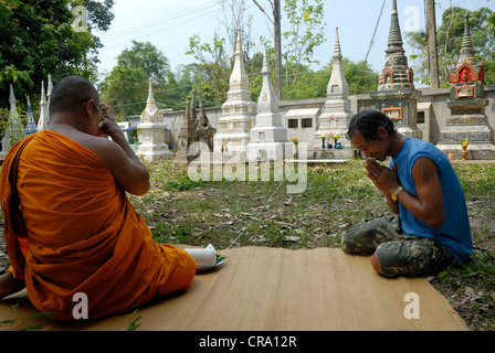 Thai Mann, der betet mit Mönch für thailändische Neujahr Songkran am 15.04.2012 in Udonthani Thailand Stockfoto