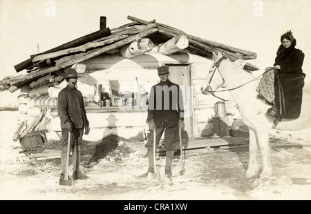 Zwei Männer & hübsches Mädchen auf Rohöl Log Cabin Stockfoto