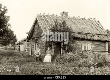 Zwei ältere Frauen vor Stroh Dach Log Cabin Stockfoto