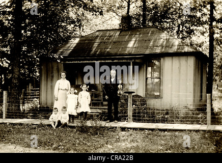 Familie von sechs vor kleinen Hütte Stockfoto