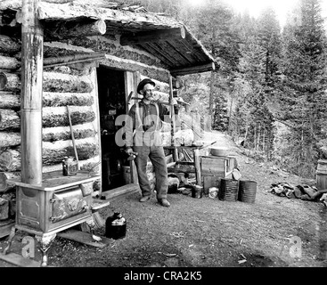 Ältere Arbeiten Mann vor Blockhütte Stockfoto