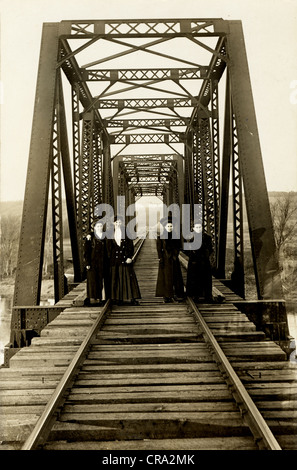 Vier Mädchen Bummeln auf Eisenbahnschienen auf Brücke Stockfoto