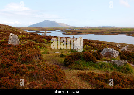 Der Steinkreis Pobull Fhinn Finns Personen über dem Loch Langais mit Eabhal im Hintergrund, auf North Uist. Stockfoto