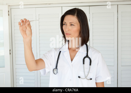 Frau Prüfung Thermometer im Haus Stockfoto