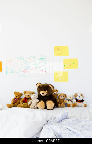 Teddybären und Childs Zeichnungen auf Bett Stockfoto