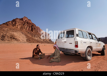 Beduinen und jordanische ruht im Schatten der Geländewagen in die Wüste, roter Sand, Berg, Wadi Rum Stockfoto