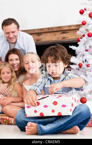 Junge Weihnachtsgeschenk öffnen Stockfoto