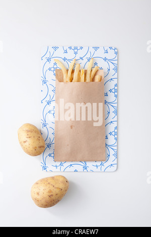 Pommes frites in einer braunen Papiertüte, Kartoffeln Stockfoto