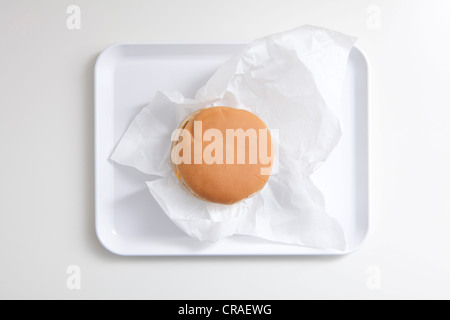 Hamburger auf einem weißen Tablett mit Butterbrotpapier Stockfoto