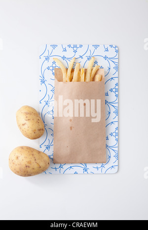 Pommes frites in einer braunen Papiertüte, Kartoffeln Stockfoto