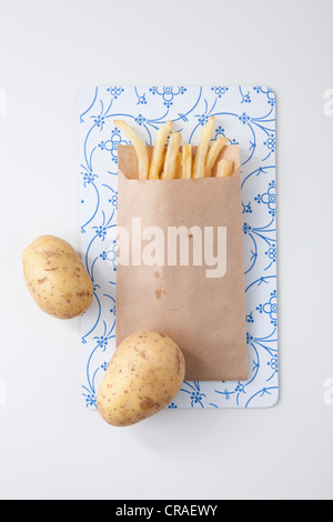 Pommes frites in einer braunen Papiertüte, Kartoffeln Stockfoto