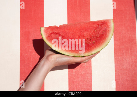 Stück von Wasser Melone, rot und weiß gestreiften Strandkorb Stockfoto