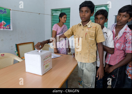 Jungen setzen Stimmzettel in die Abstimmung Box, Mini Kutties Rajiyam, Panchayat Wahlen, Noyyal Maravapalayam in der Nähe von Karur, Tamil Nadu Stockfoto