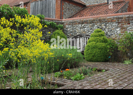 Die Outdoor-Kräutergarten im Frühjahr auf Burg Hektar großen Priorat, Norfolk - einen alten hölzernen Sitz im Hintergrund Stockfoto