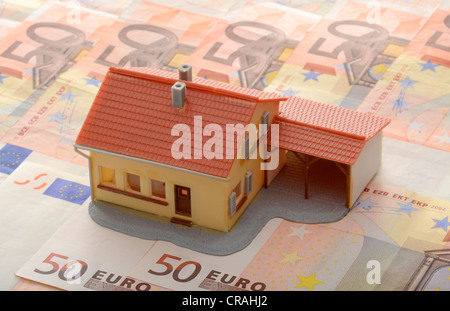 Miniaturhaus mit Carport auf 50 Euro-Banknoten, symbolisches Bild für Immobilienmarkt Stockfoto