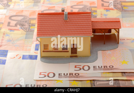 Miniaturhaus mit Carport auf 50 Euro-Banknoten, symbolisches Bild für Immobilienmarkt Stockfoto