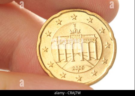 Finger halten eine zwanzig-Cent-Euro-Münze mit dem Brandenburger Tor, Makro Stockfoto