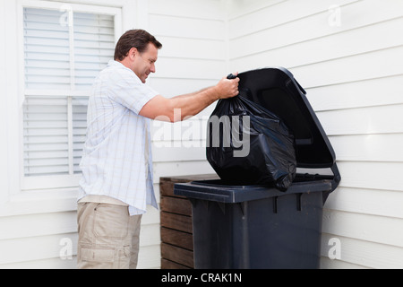 Mann unter Müll raus Stockfoto