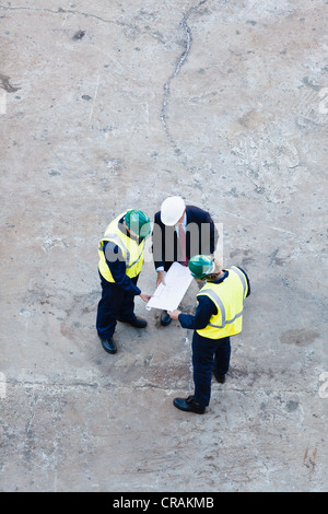 Arbeitnehmer, die Baupläne im Trockendock zu lesen Stockfoto