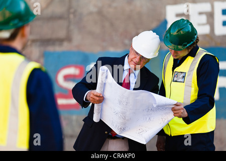 Arbeitnehmer, die Baupläne auf Trockendock zu lesen Stockfoto