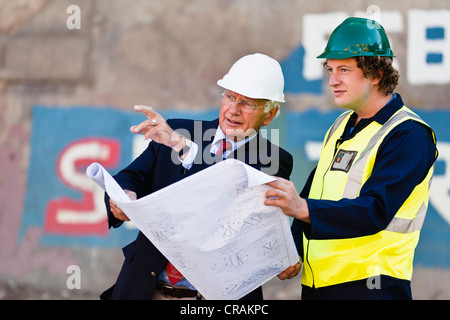 Arbeitnehmer, die Baupläne auf Trockendock zu lesen Stockfoto