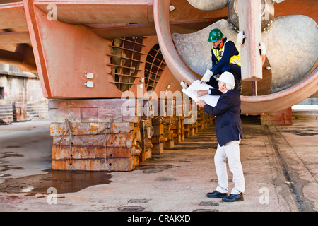 Arbeitnehmer im Propeller am Trockendock sprechen Stockfoto