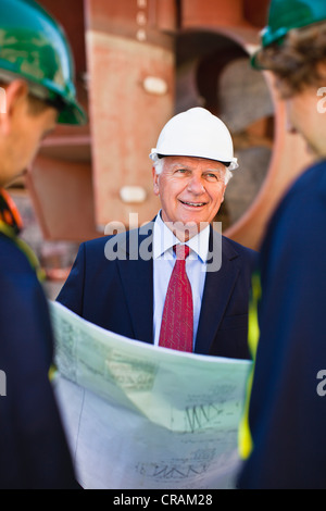 Arbeitnehmer, die Baupläne auf Trockendock zu lesen Stockfoto