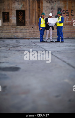 Arbeitnehmer, die Baupläne auf Trockendock zu lesen Stockfoto