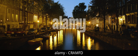 Kanalhäuser mit Blick auf einen Kanal in der Stadt Amsterdam bei Nacht. Stockfoto