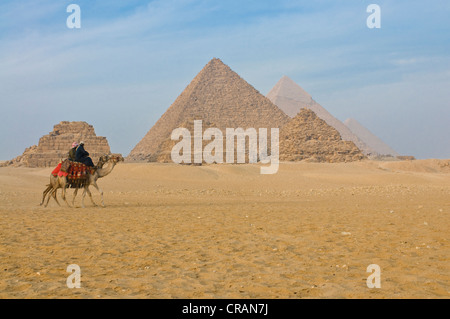 Reiter auf einem Kamel vor den Pyramiden von Gizeh, UNESCO World Heritage Site, Ägypten, Afrika Stockfoto