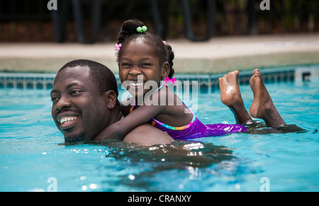 Vater und Tochter spielen in einem Schwimmbad. Stockfoto