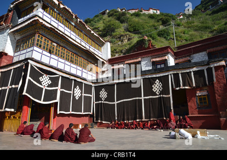 Tibetischen Buddhismus sitzen tibetische Mönche in roten Gewändern, die Teilnahme an einer Zeremonie in Vorbereitung der Himmel Bestattung eines Körpers liegen auf einem Stockfoto