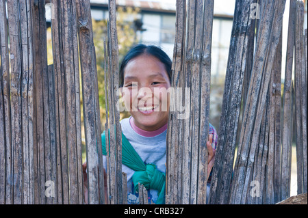 Indianerin schaut durch ein Loch in einen Zaun, Arunachal Pradesh, North East India, Indien, Asien Stockfoto