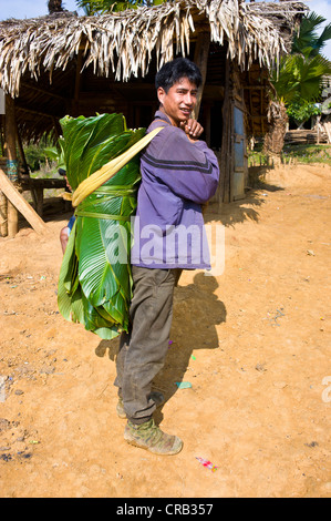 Mann mit Bambus verlässt Haus im traditionellen Dorf von Paia nahe entlang, Arunachal Pradesh, North East India, Indien, Asien Stockfoto