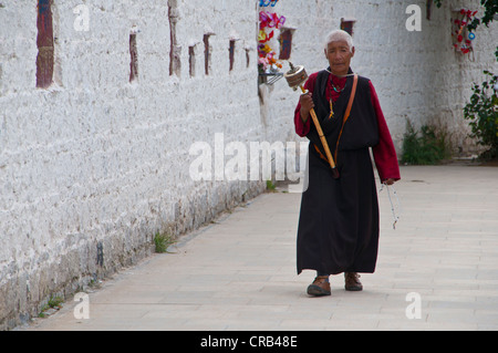 Pilger mit einer Gebetsmühle vor dem Potala-Palast, UNESCO-Weltkulturerbe, Lhasa, Tibet, Asien Stockfoto